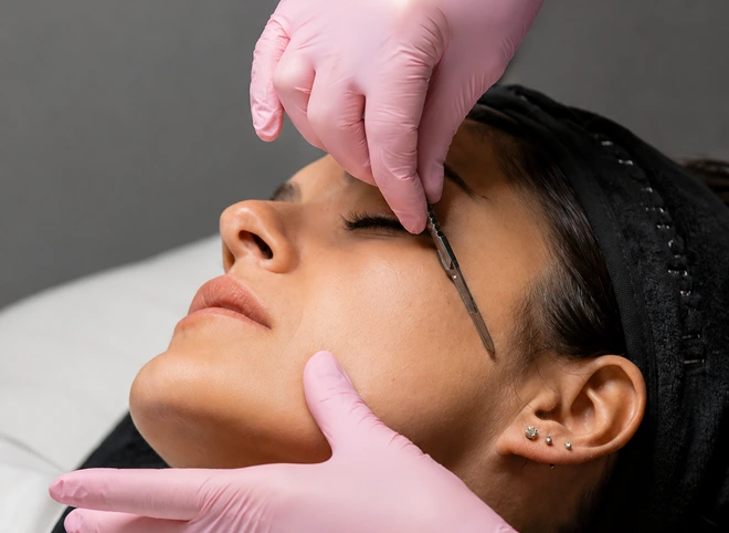 Esthetician performing dermaplaning during a facial