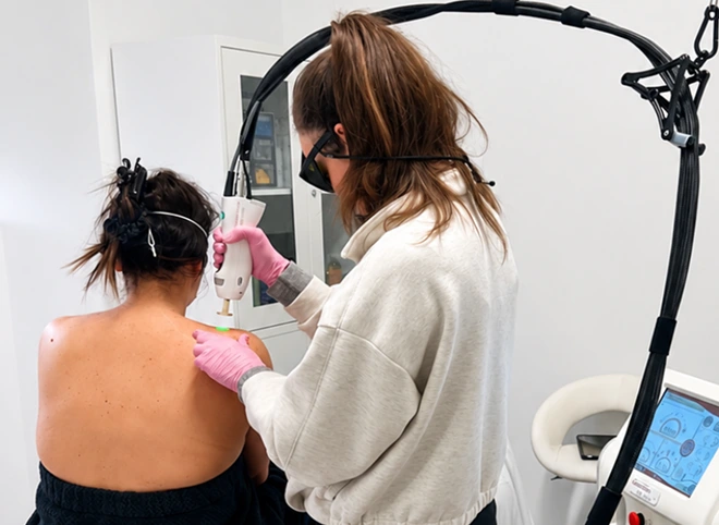 Provider using the GentleMax Pro Plus laser on a patient's shoulder