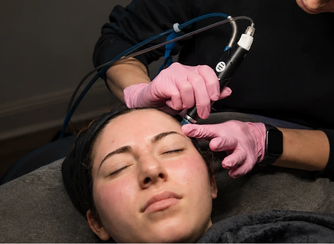Provider performing a HydraFacial on a relaxed patient