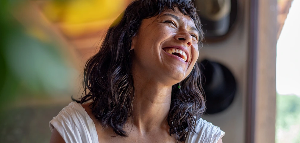 Energetic woman laughing, representing vitamin shot benefits