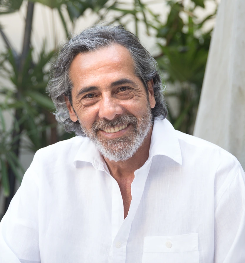 Smiling mature man with full gray hair, representing hair thinning and scalp health care