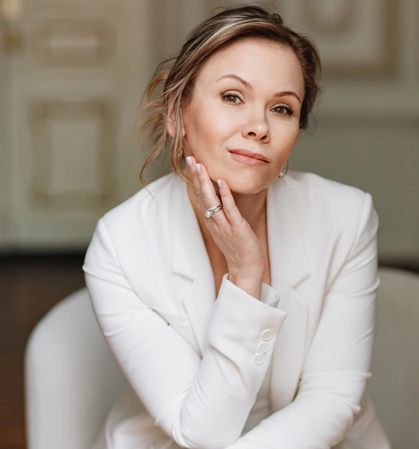 Poised woman in a white blazer with firm skin, representing skin laxity treatment